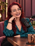 Caroline Swan at a podcast microphone in a teal blouse